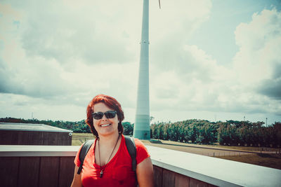 Portrait of smiling young woman against sky