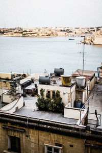 High angle view of buildings by sea against sky