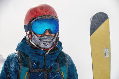 Closeup portrait of ski goggles of a man with reflection of snowy mountains. the mountain range is