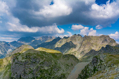 Scenic view of mountain range against cloudy sky