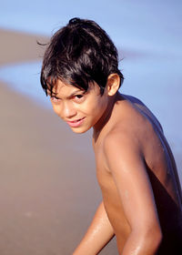 Portrait of shirtless boy on beach