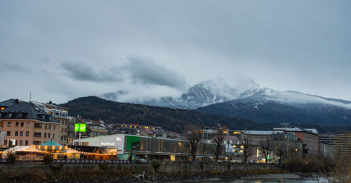 Houses on snowcapped mountain against sky