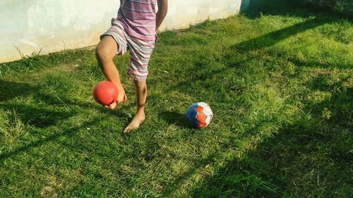 Low section of boy playing with ball on field