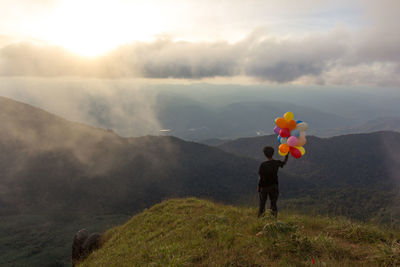 Man standing on mountain against sky