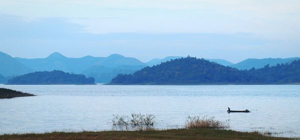 Scenic view of lake by mountains against sky