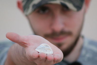 Close-up portrait of man holding shell