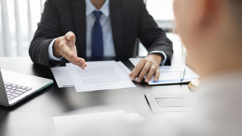 Midsection of businessman working on table