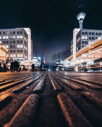Railroad tracks in city against sky at night