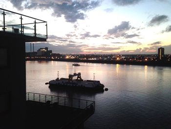 Boats in river at sunset