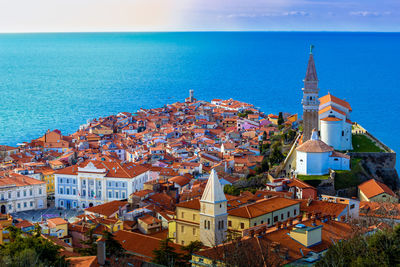 High angle view of townscape by sea against sky