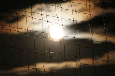 Close-up of fence against sunset sky