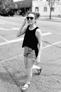 Portrait of happy young woman wearing sunglasses standing outdoors