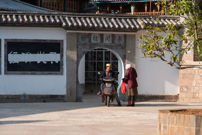 Rear view of man and woman walking in building