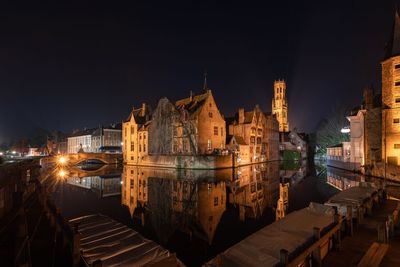 Illuminated buildings in city against sky at night