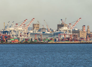 Boats in sea against clear blue sky