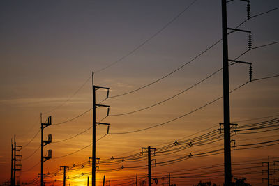 Low angle view of silhouette electricity pylon against the romantic sky