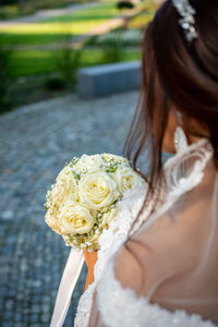 Bride with rose bouquet in city