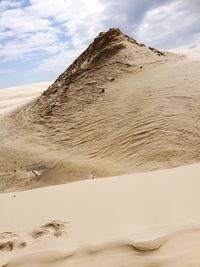 Sand dunes in desert against sky