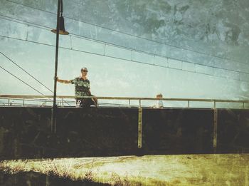 Man standing by railing against wall