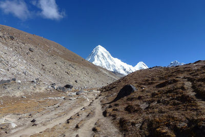 Scenic view of snowcapped mountains against blue sky