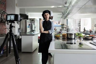 Female kitchen trainee standing in kitchen