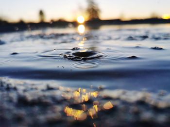 Close-up of water splashing against sky during sunset