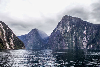 Scenic view of lake by mountains against sky