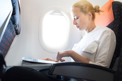Young woman sitting in airplane
