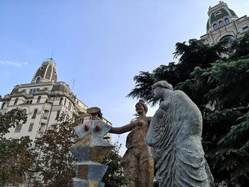 Low angle view of statue against building and sky