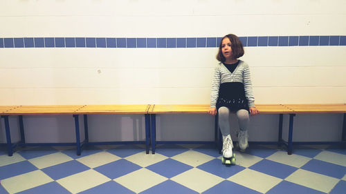 Girl standing against tiled wall