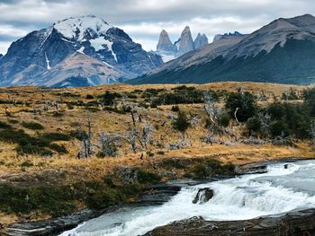 Scenic view of river and snowcapped mountains against sky