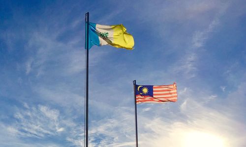 Low angle view of flags against blue sky