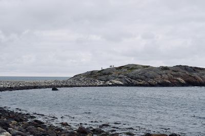 Rocks by sea against sky