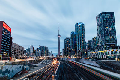 Cn tower with cityscape against sky at dusk