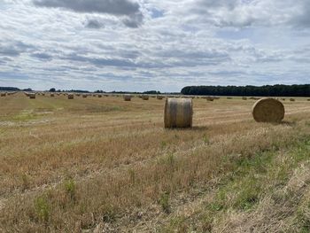 Hay bales on field against sky