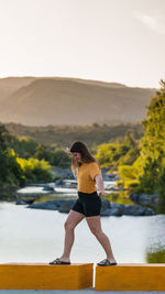 Full length of woman standing on lake against sky