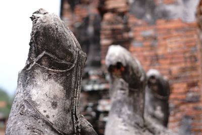 Close-up of old statue against temple