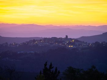 Scenic view of silhouette mountains against romantic sky at sunset