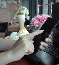 Midsection of woman holding ice cream on table