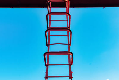 Low angle view of ladder against blue sky