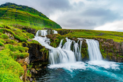 Scenic view of waterfall against sky