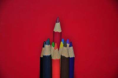 Close-up of colored pencils against red background