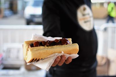 Midsection of man holding hot dog