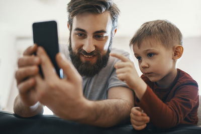 Portrait of father and little son with smartphone
