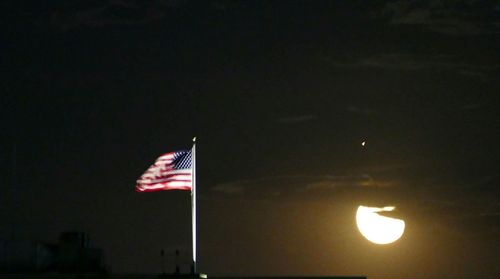 Low angle view of flag against sky at night