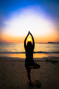 Rear view of person at beach during sunset