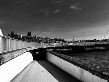 Bridge over river against sky in city