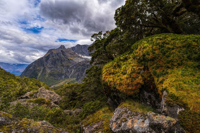 Scenic view of waterfall and mountains against sky