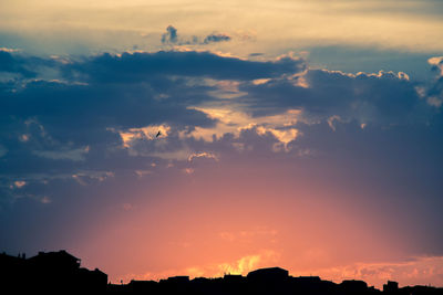 Low angle view of silhouette landscape against dramatic sky