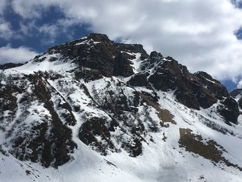 Low angle view of snowcapped mountains against sky